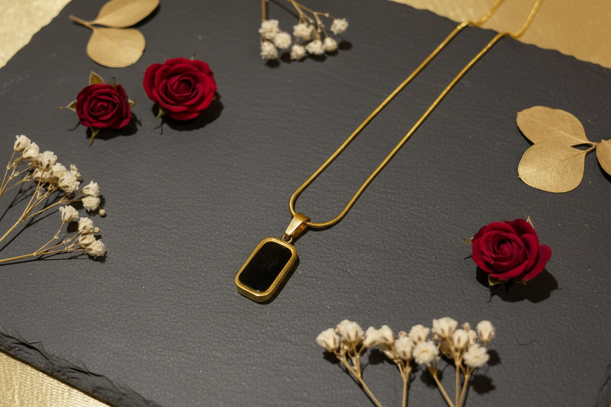 Black onyx gold pendant necklace editorial flat lay